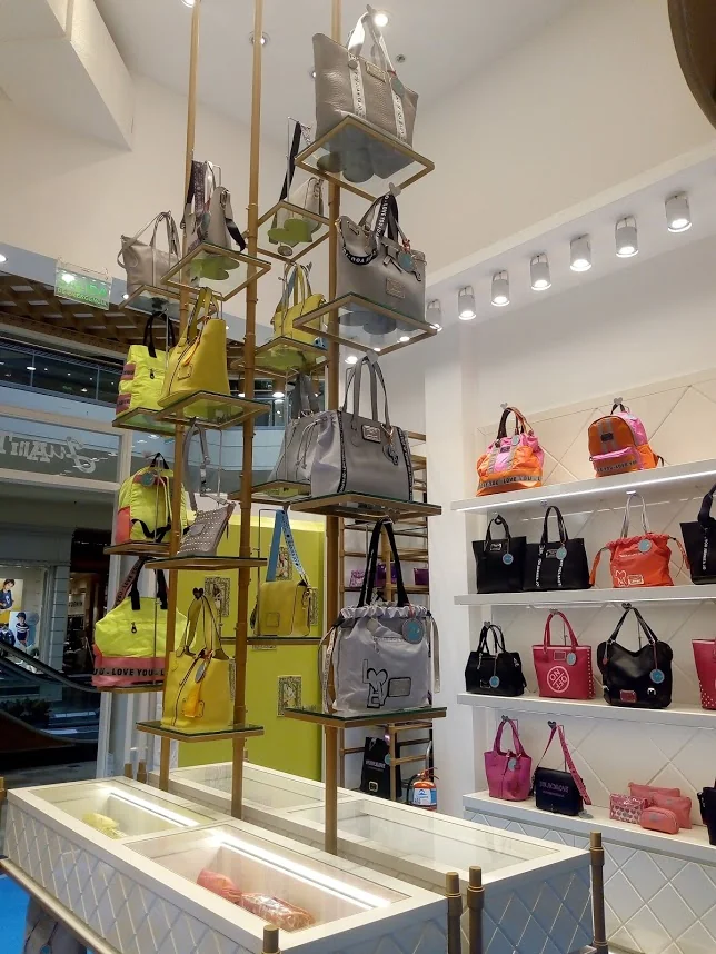 Interior del local de 2019: exhibidores de estructura dorada, vitrinas y paredes de exhibición